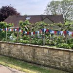 red white and blue bunting adorns the front wall of a village house